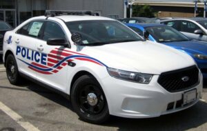 A marked Metropolitan Police Department Ford Police Interceptor patrol cruiser parked along a city street.