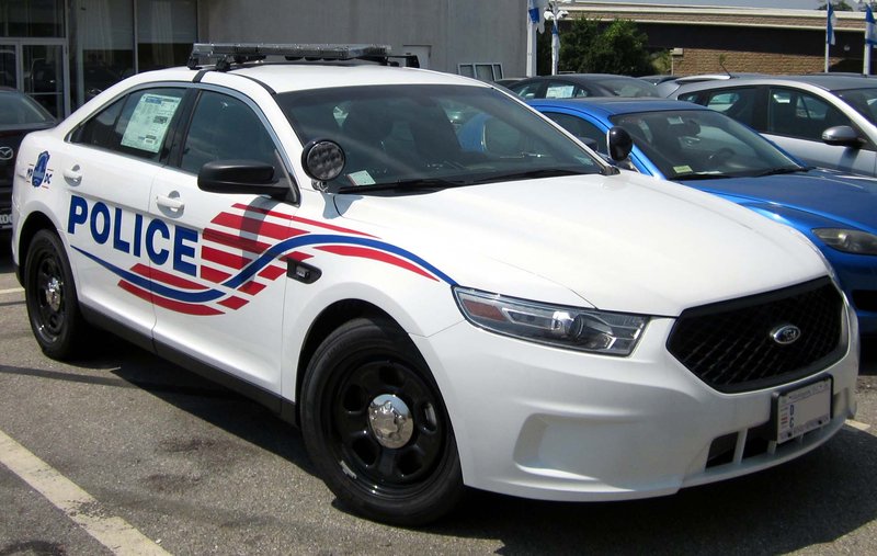 A marked Metropolitan Police Department Ford Police Interceptor patrol cruiser parked along a city street.