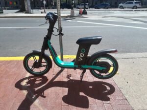 A shared electric scooter parked along a street curb in Washington, D.C.